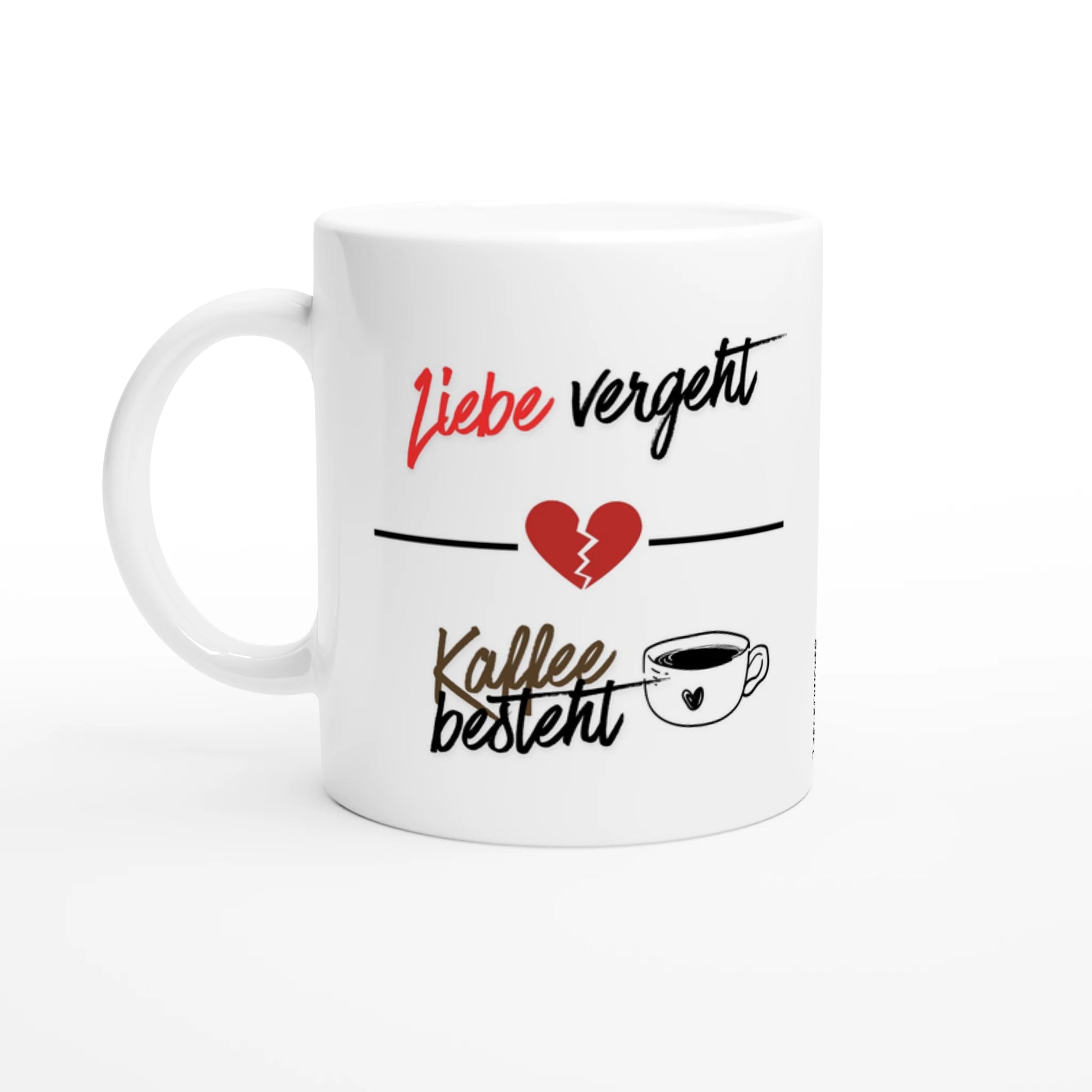 Eine weiße Keramiktasse mit einem zweigeteilten Spruch. Oben steht in roter und schwarzer Schreibschrift „Liebe vergeht“, getrennt durch eine horizontale Linie mit einem gebrochenen roten Herz in der Mitte. Darunter steht in brauner und schwarzer Schrift „Kaffee besteht“, ergänzt durch die Illustration einer kleinen Kaffeetasse mit einem Herz-Symbol.

