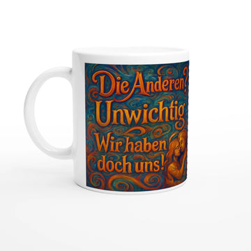 „Weiße Keramiktasse auf weißem Hintergrund mit einem farbenfrohen, kunstvollen Aufdruck im Wirbel-Stil. Der Text lautet: ‚Die Anderen? Unwichtig. Wir haben doch uns!‘. Rechts unten ist eine stilisierte Illustration eines sich umarmenden Paares zu sehen.“