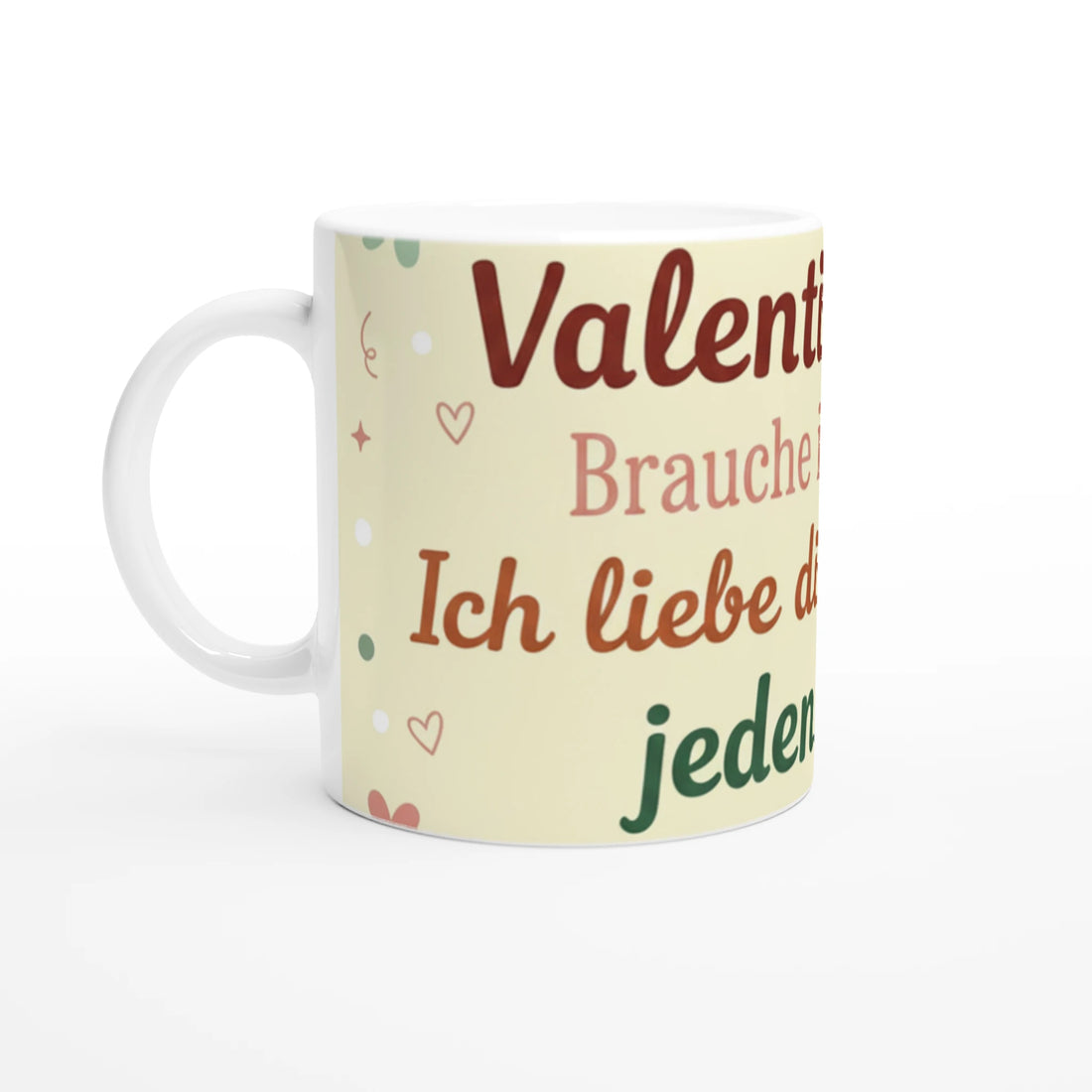 Weiße Keramiktasse mit einem vollflächigen, hellgelben Design-Element. In der Mitte steht der Spruch „Valentinstag? Brauche ich nicht. Ich liebe dich jeden Tag!“ in verschiedenen Braun- und Grüntönen. Das Design ist mit kleinen Herzen, Sternen und Schnörkeln verziert.