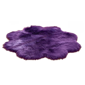 Lila Kunstfellteppich mit flauschiger, unregelmäßig runder Form auf weißem Hintergrund.